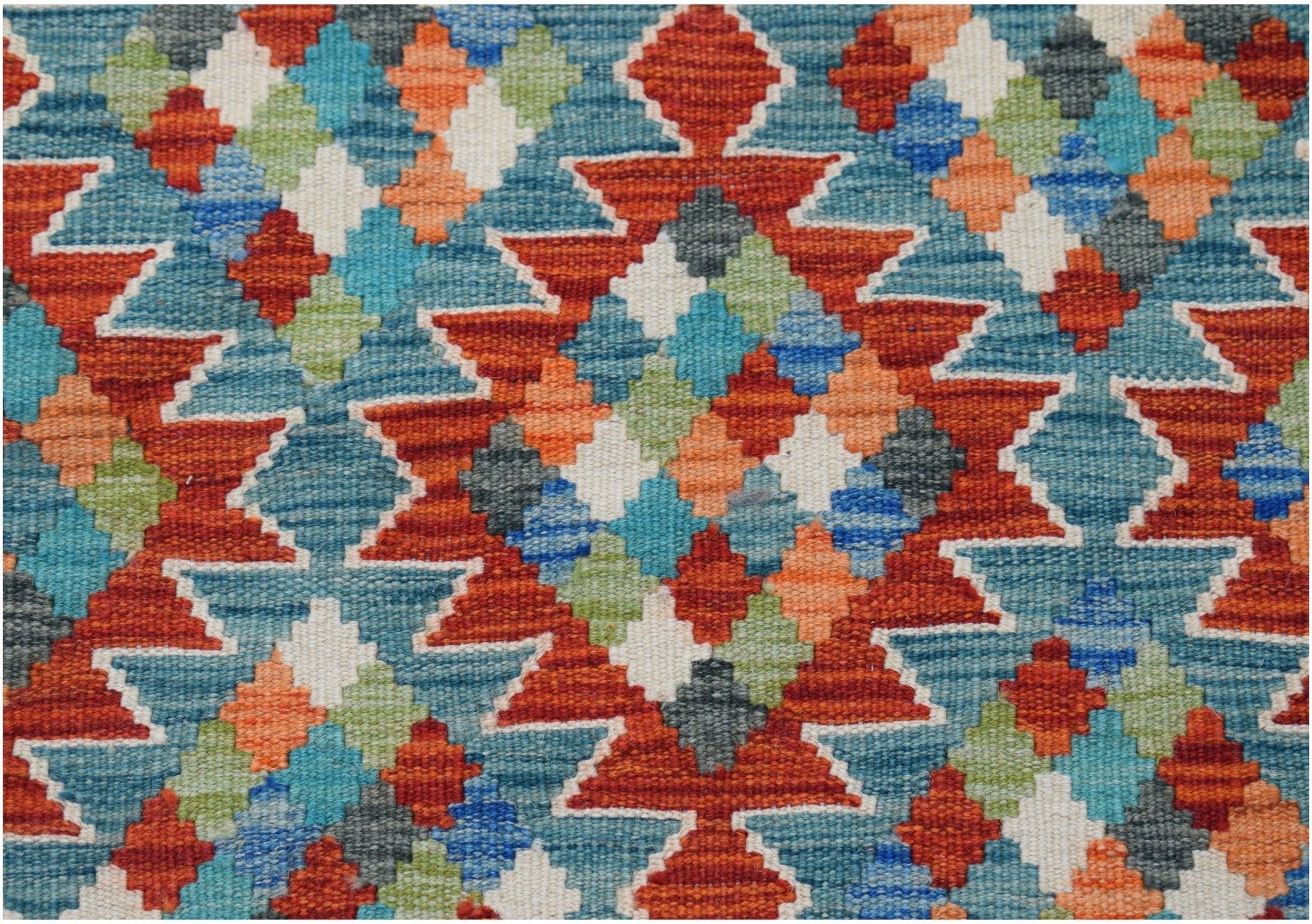 Handwoven Afghan Maimana kilim rug featuring a vibrant geometric pattern in wool.