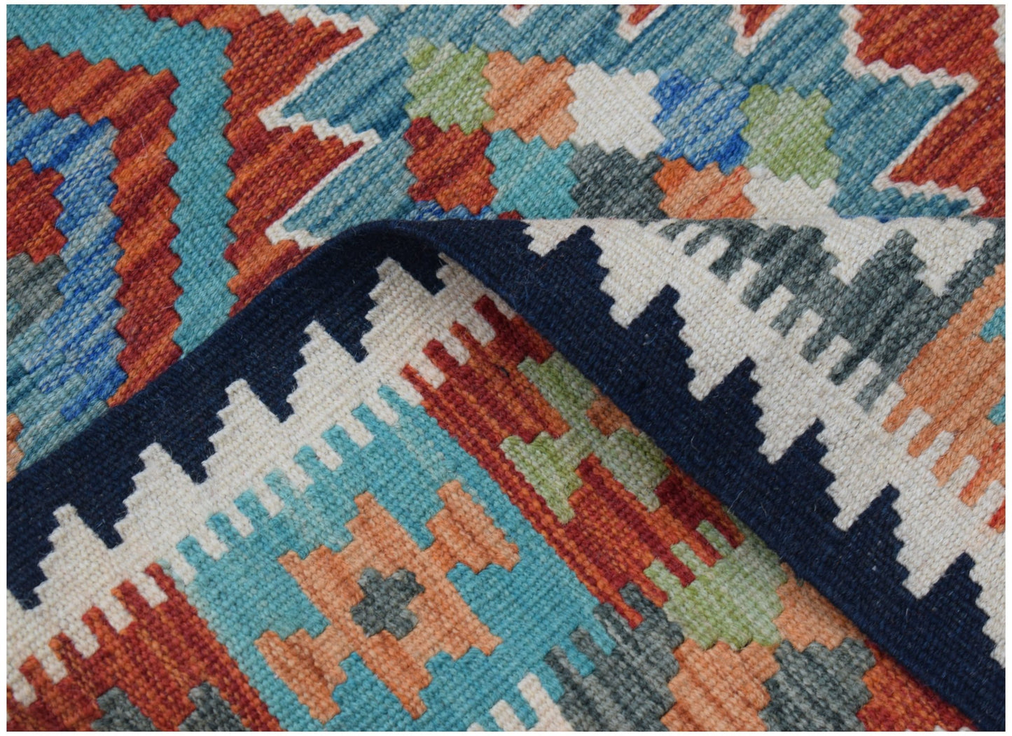 A handmade Afghan Maimana kilim rug featuring a colorful geometric pattern in a flatweave wool.