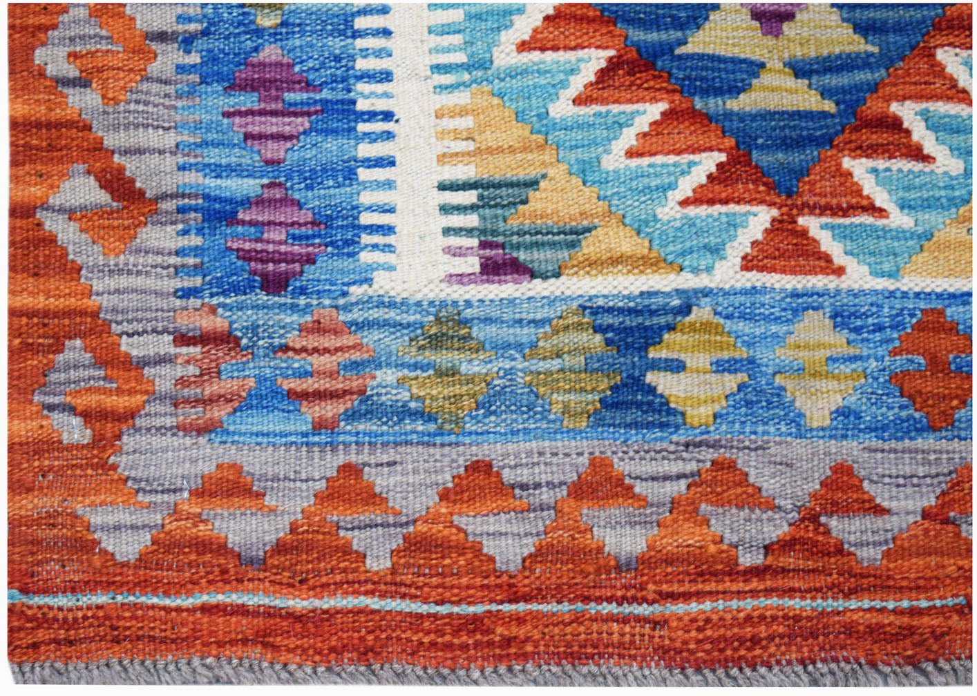 Handwoven Afghan Maimana kilim rug featuring a vibrant geometric pattern in wool.