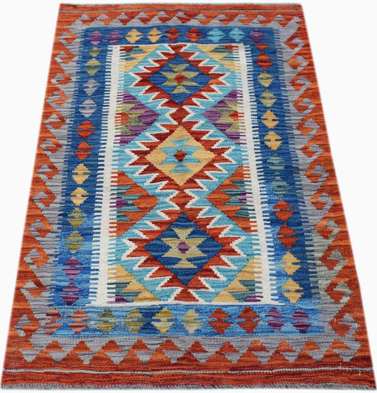 Handwoven Afghan Maimana kilim rug featuring a vibrant geometric pattern in blue and orange.