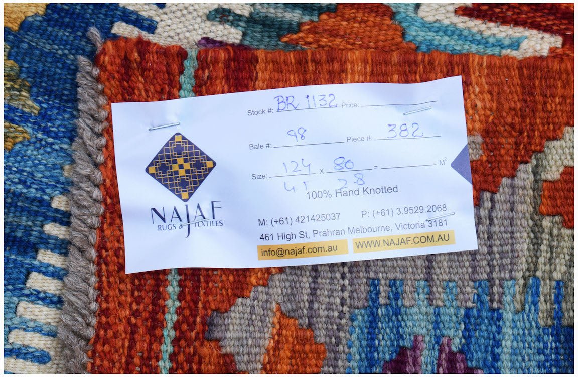 A close-up of a handwoven Afghan Maimana Kilim featuring vibrant geometric patterns in wool.