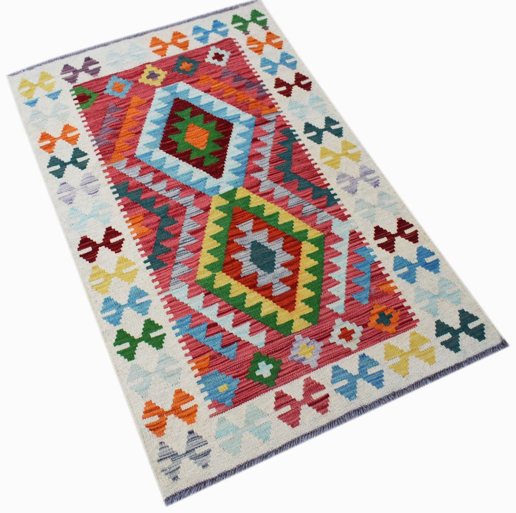 Handwoven Afghan Maimana kilim rug featuring a vibrant geometric pattern in wool.