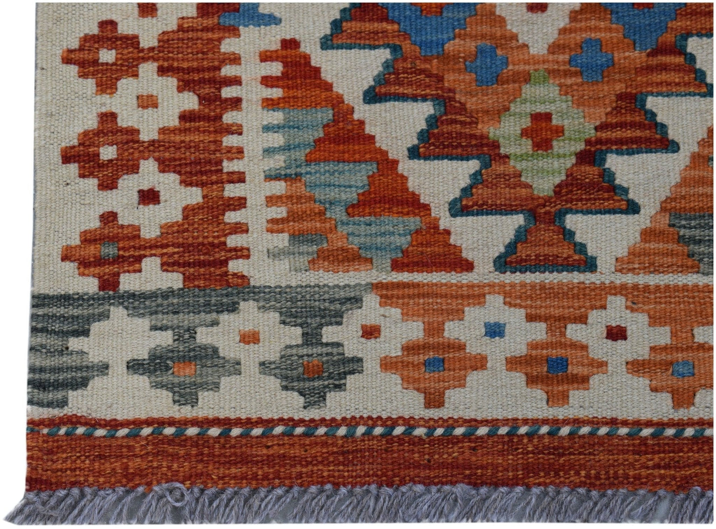 Handwoven Afghan Maimana kilim rug featuring geometric patterns in orange, blue, and grey wool.