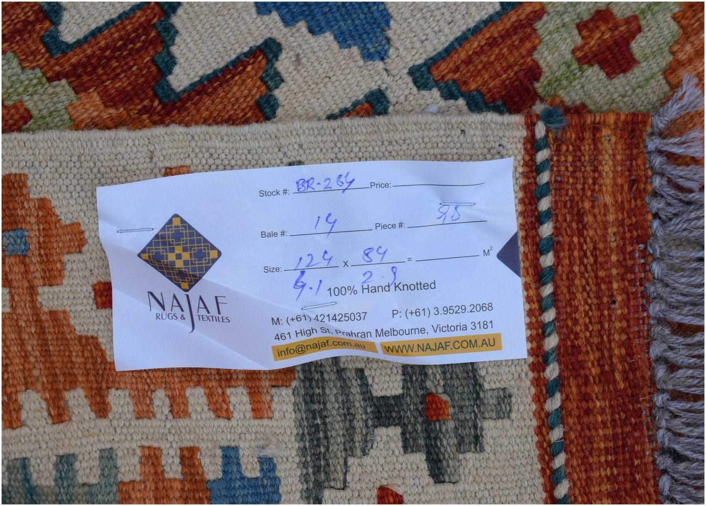 A handwoven Afghan Maimana kilim featuring a geometric pattern in orange, blue, and cream tones.