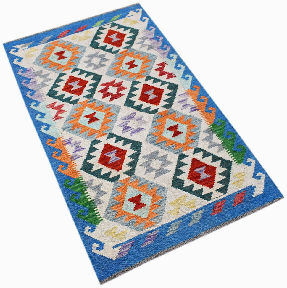 Handwoven Afghan Maimana kilim rug featuring a geometric pattern in vibrant colors on a white base.
