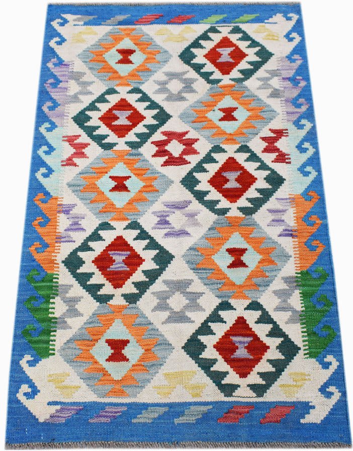 Handwoven Afghan Maimana kilim rug featuring a colorful geometric diamond pattern on a cream base.
