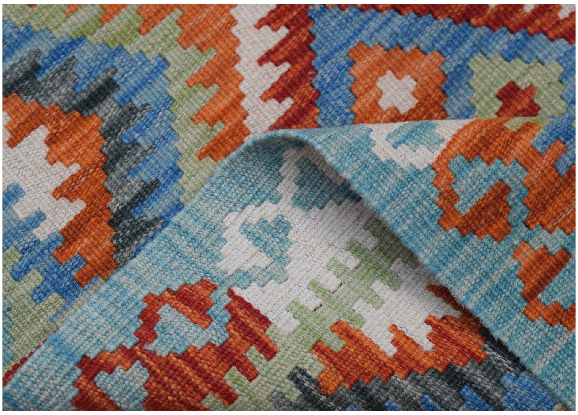 A handmade Afghan Maimana kilim rug featuring a vibrant geometric pattern in wool.