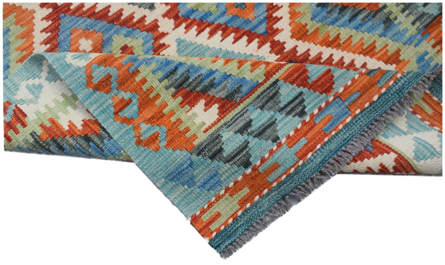 A handmade Afghan Maimana kilim rug featuring a geometric pattern in blue, orange, and green.