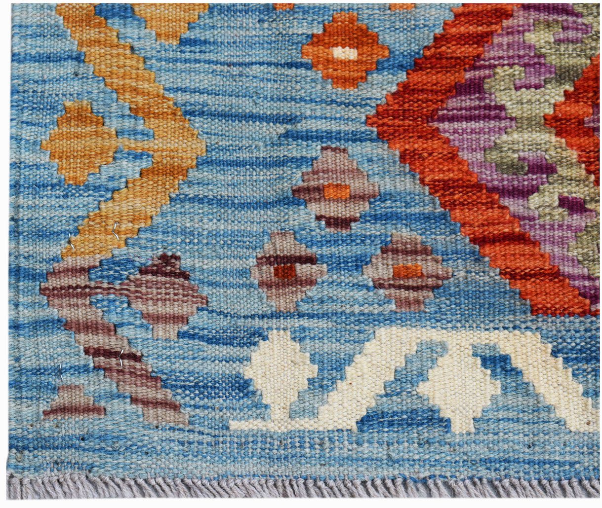 Handwoven Afghan Maimana kilim featuring a blue background with geometric orange and purple patterns.