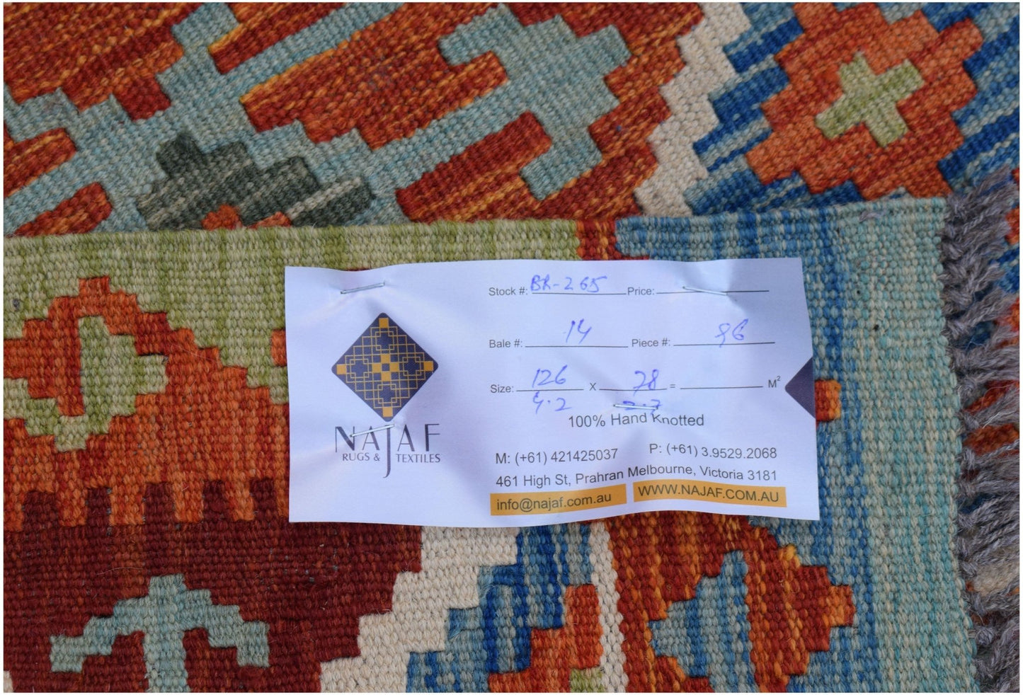 A handwoven Afghan Maimana kilim featuring a vibrant geometric pattern in wool.