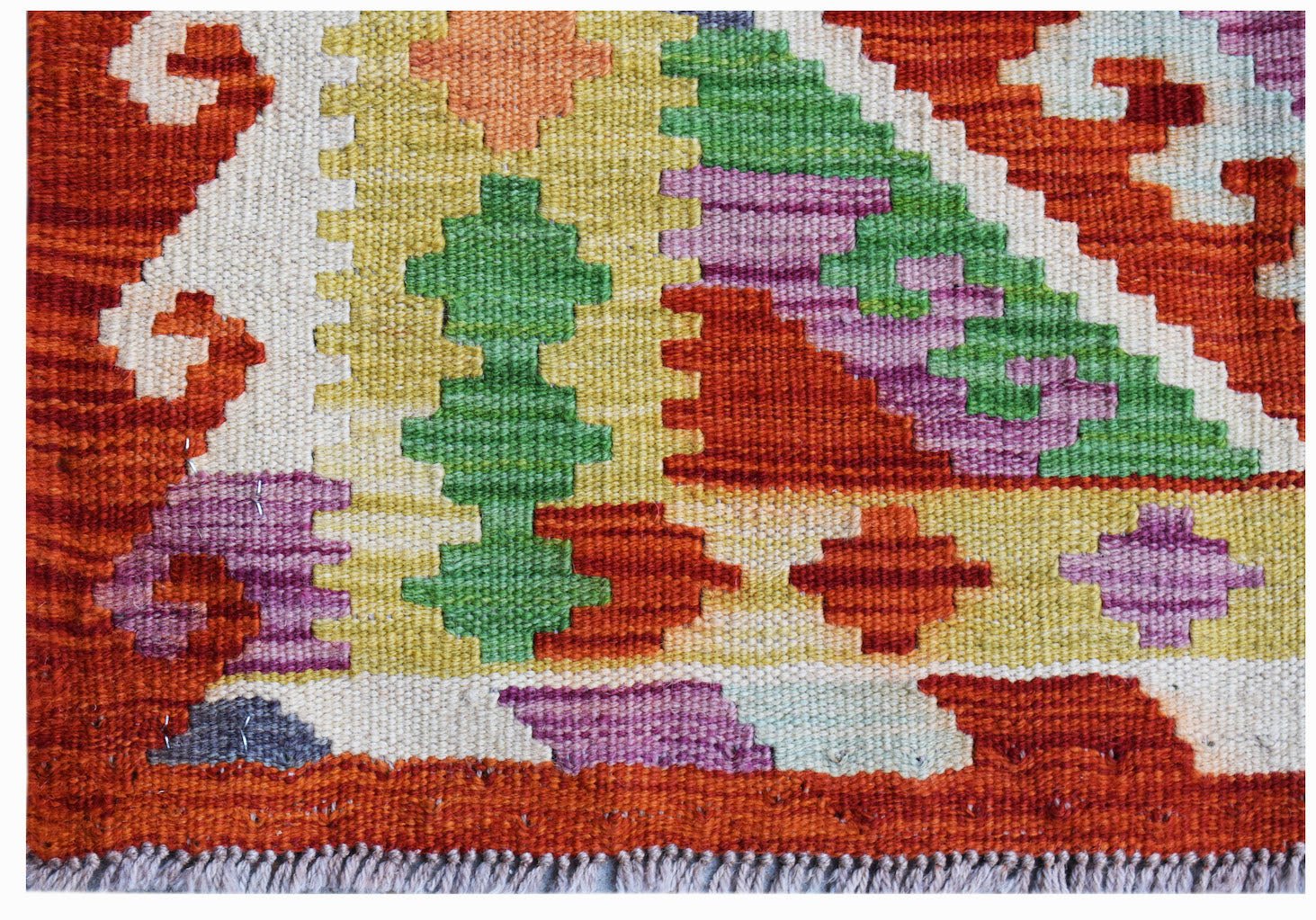 Handwoven Afghan Maimana kilim rug featuring a vibrant geometric pattern in wool.
