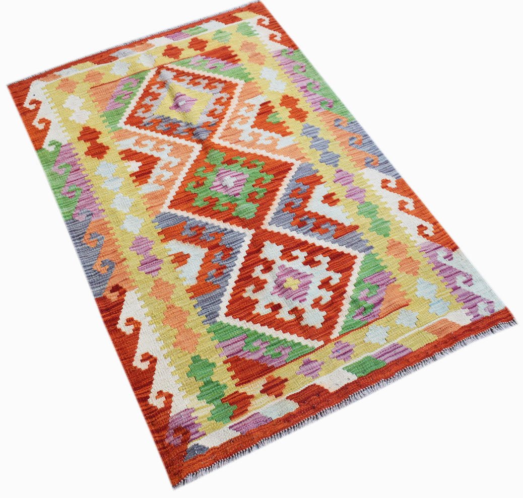 Handwoven Afghan Maimana kilim rug featuring a vibrant geometric pattern in wool.