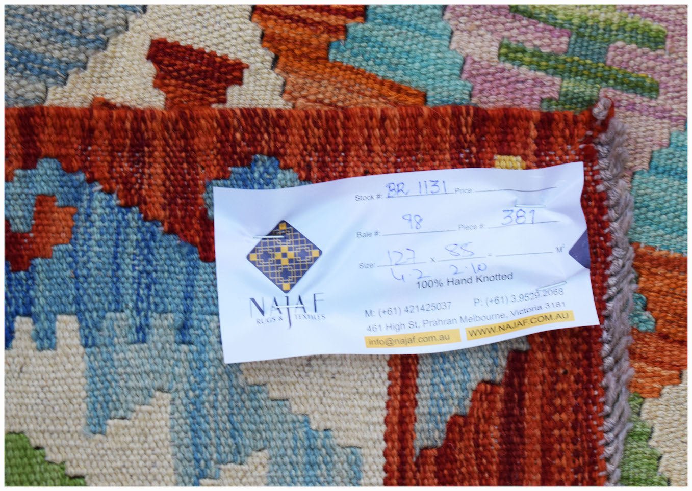 A handmade Afghan Maimana kilim featuring a vibrant geometric pattern in wool.