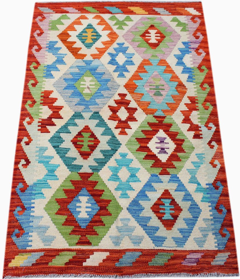Handwoven Afghan Maimana kilim rug featuring a colorful geometric diamond pattern on a cream base.