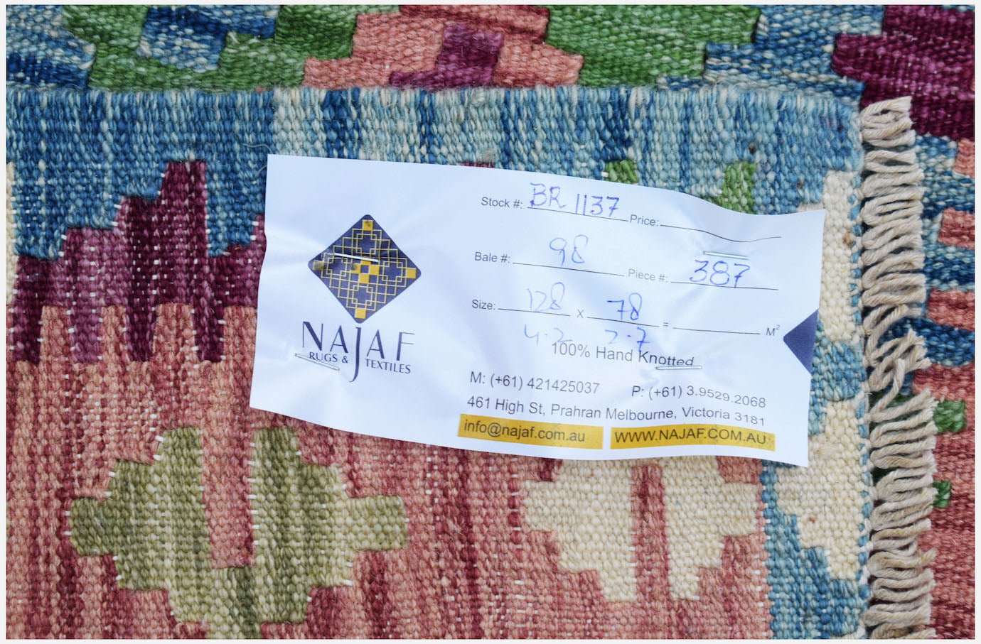 A handwoven Afghan Maimana kilim featuring a colorful geometric pattern and flatweave texture.