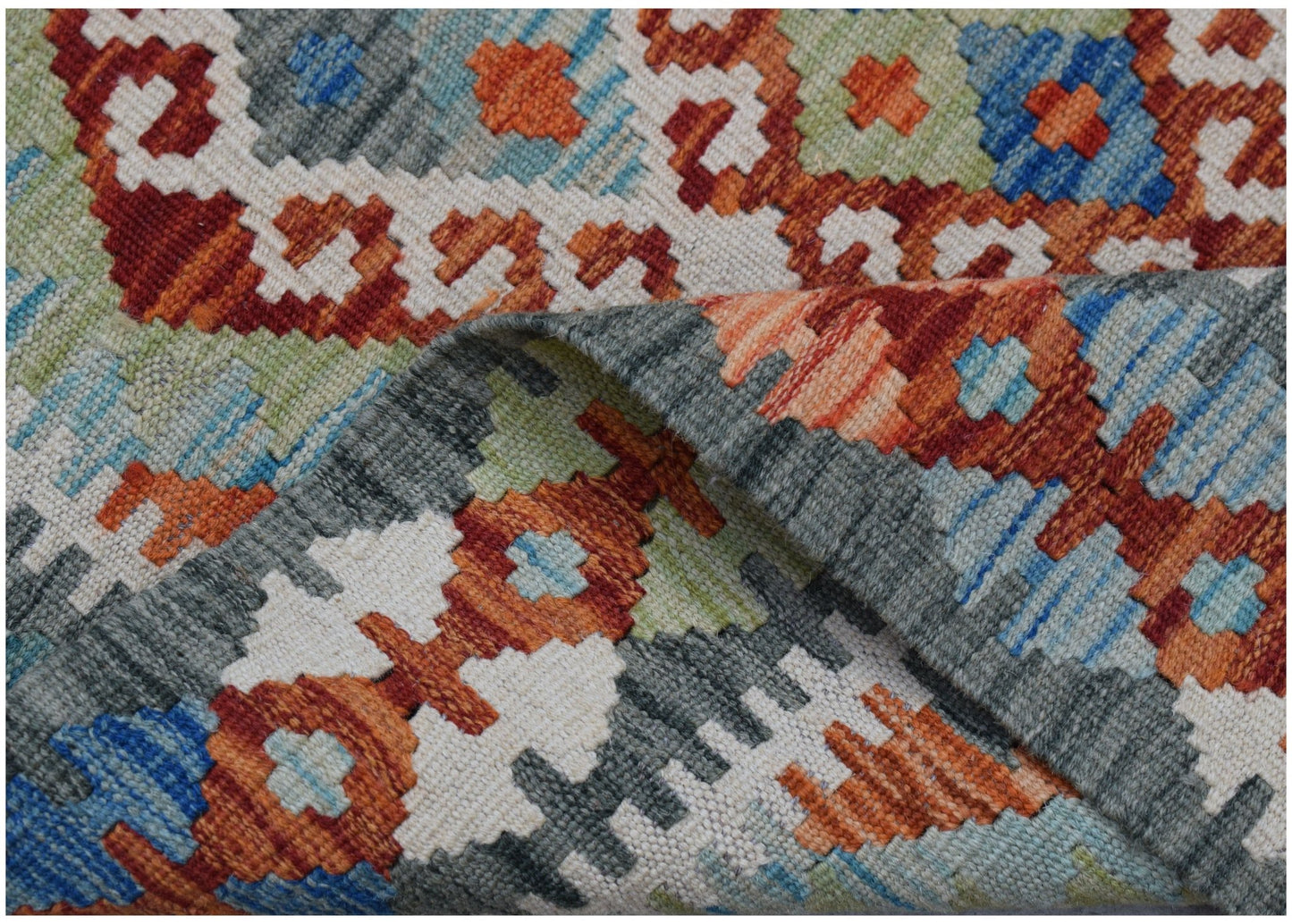 A handmade Afghan Maimana kilim rug featuring a colorful geometric pattern in wool.