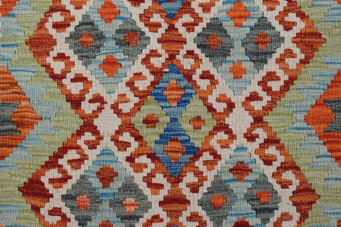 Handwoven Afghan Maimana kilim featuring a geometric pattern in orange, blue, green, and grey.