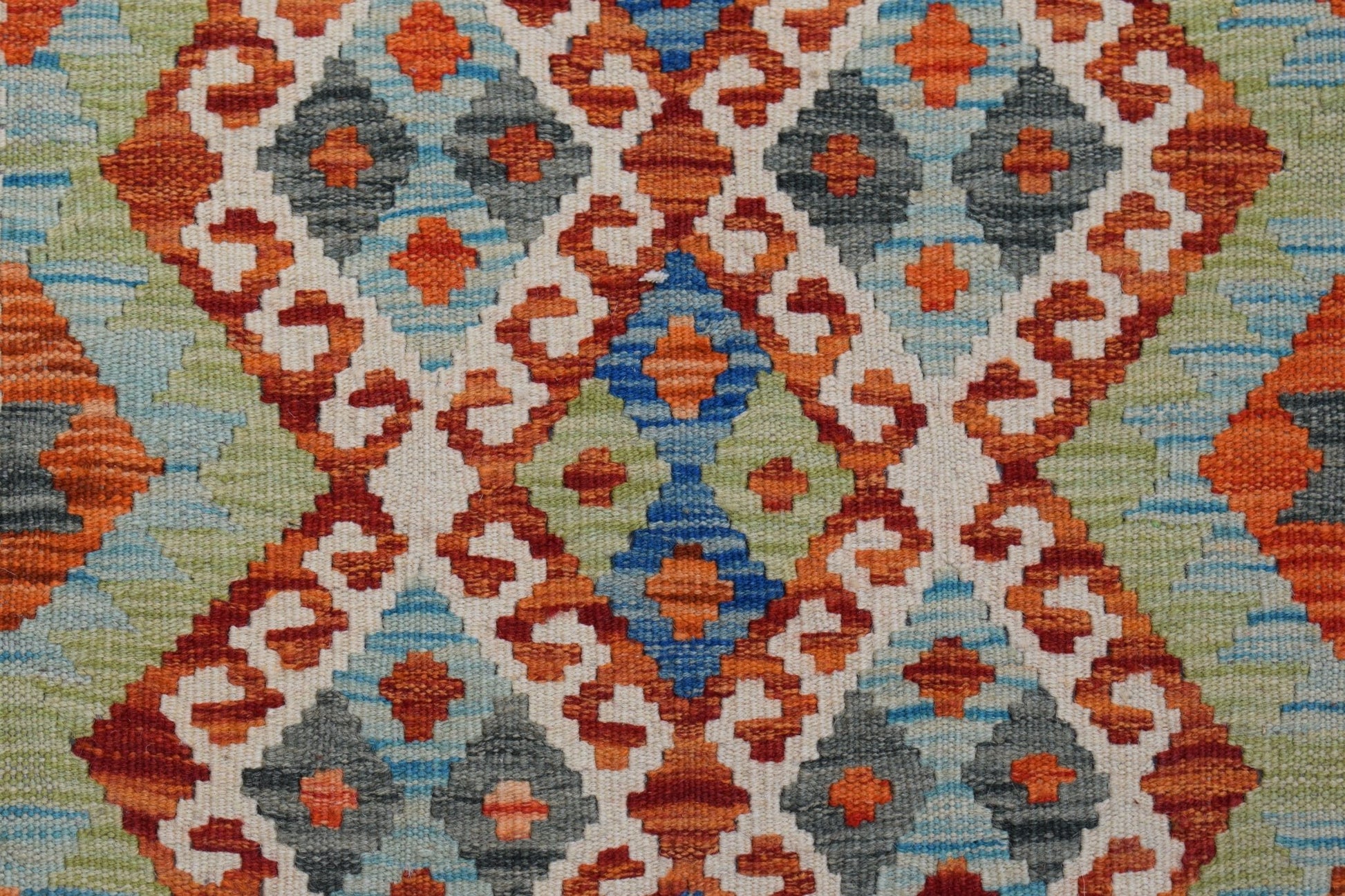 Handwoven Afghan Maimana kilim featuring a geometric pattern in orange, blue, green, and grey.