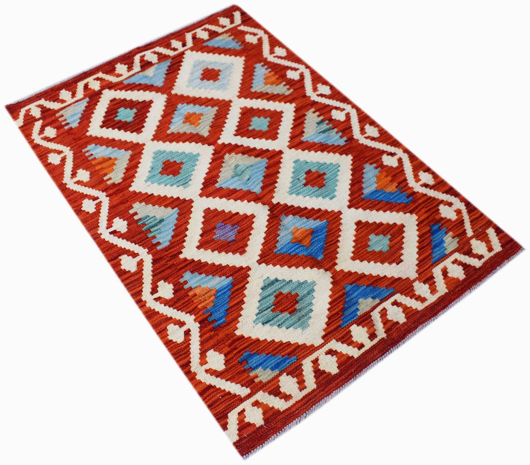 Handwoven Afghan Maimana kilim rug featuring a geometric diamond pattern in red, blue, and white.
