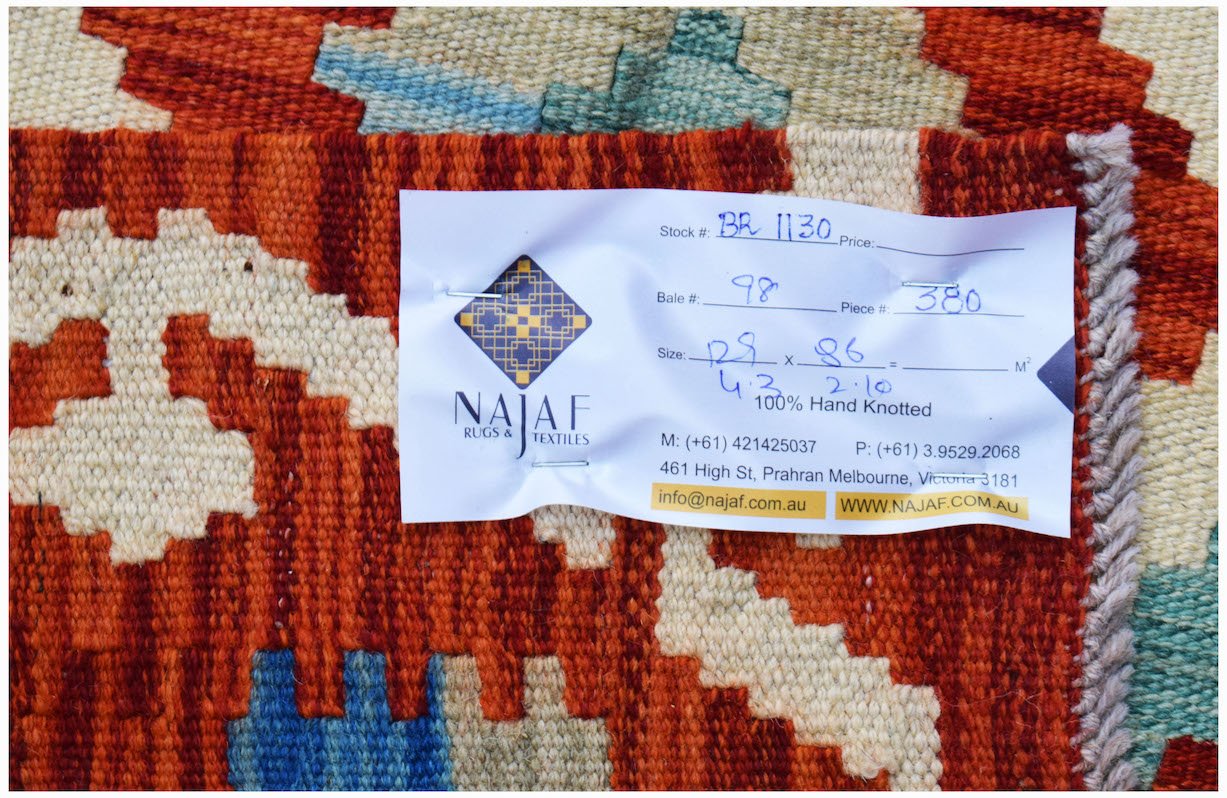 A handwoven Afghan Maimana kilim featuring a geometric pattern in shades of red, blue, and cream.