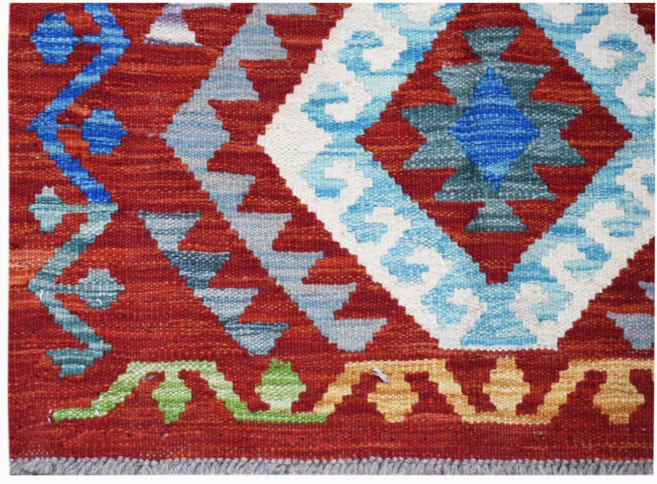 Handwoven Afghan Maimana kilim featuring a geometric diamond pattern in blue, white, and red.