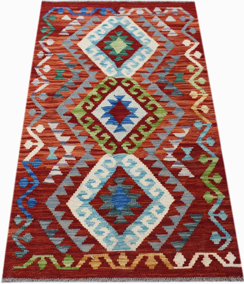 Handwoven Afghan Maimana kilim rug featuring a vibrant red background with geometric diamond motifs.