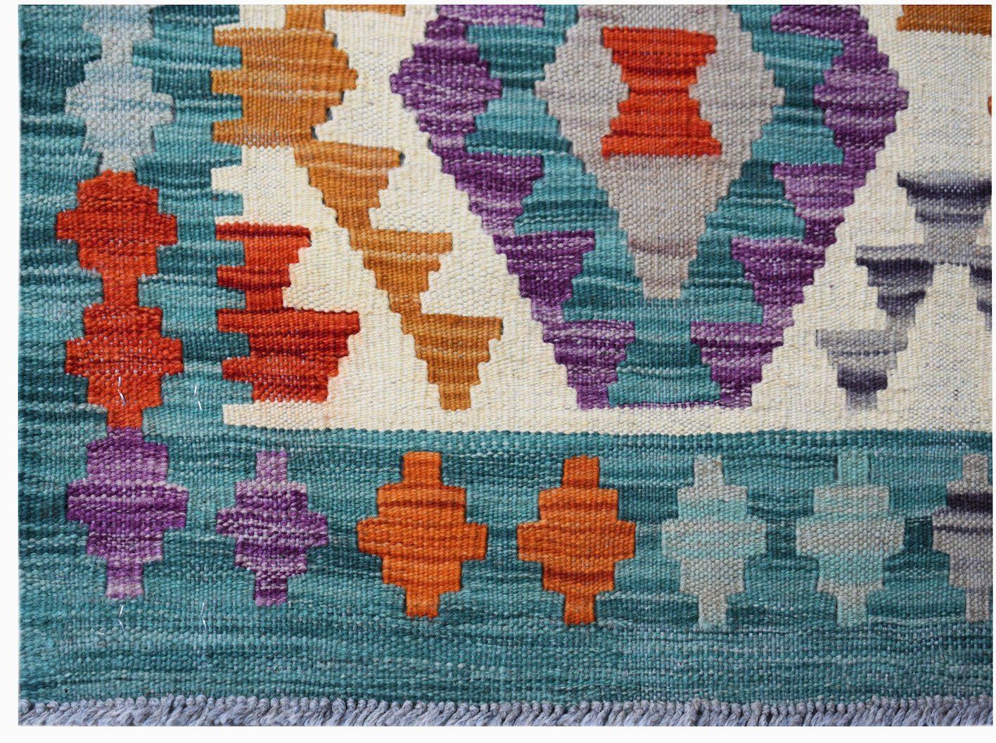 Handwoven Afghan Maimana kilim rug featuring a geometric pattern in vibrant multicolored wool.