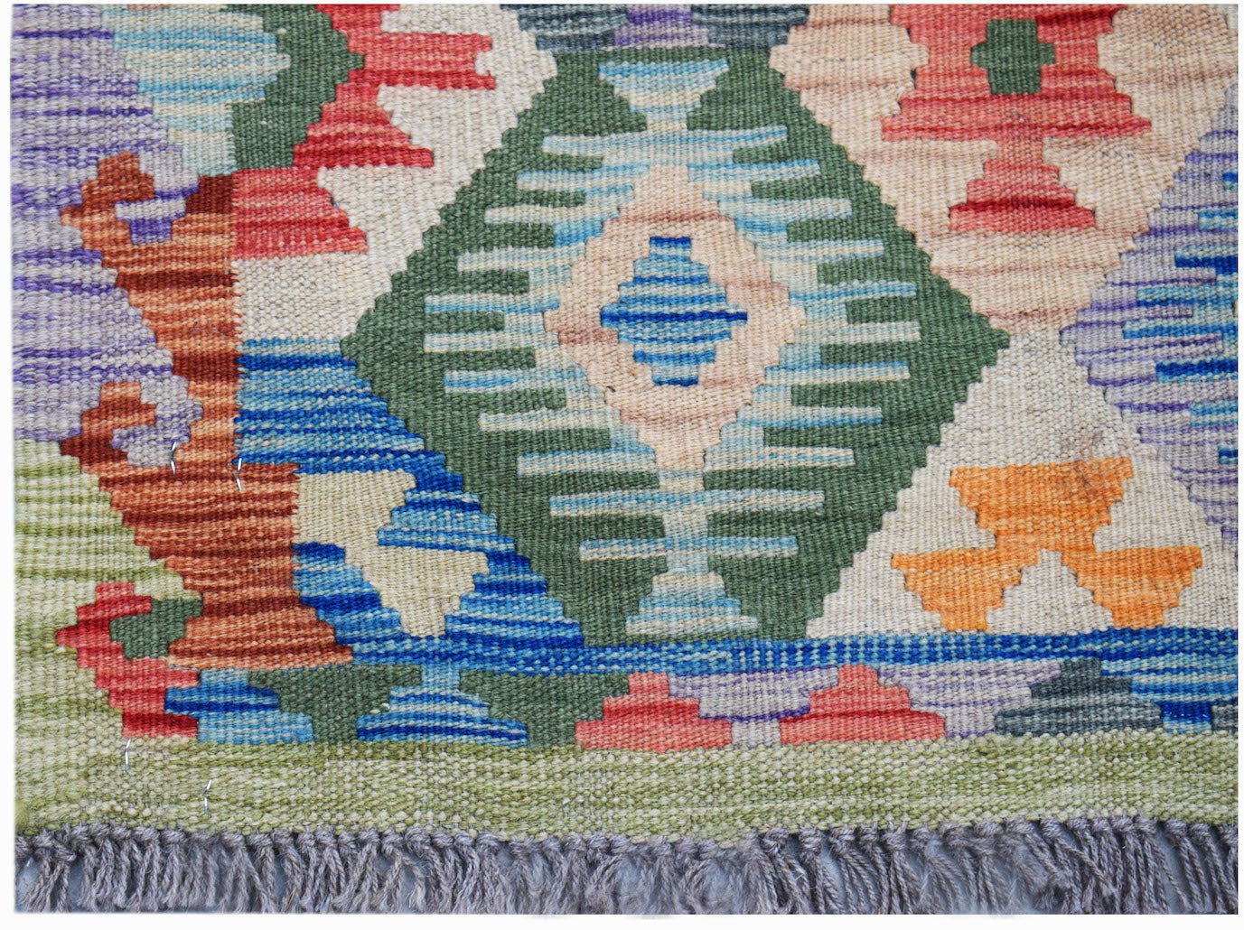Handwoven Afghan Maimana kilim rug featuring a colorful geometric pattern in wool.