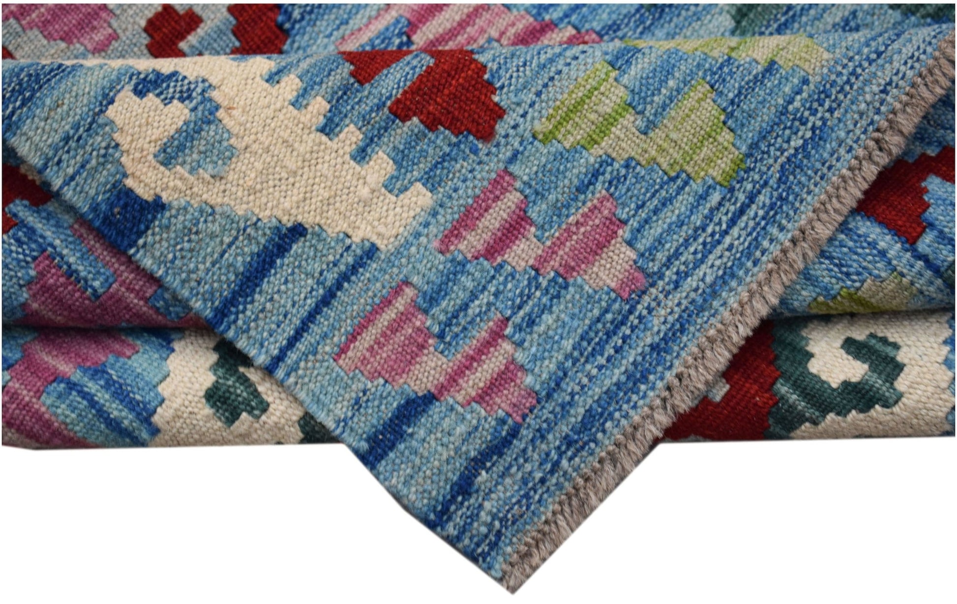 A handwoven Afghan Maimana kilim rug featuring a geometric pattern in blue, red, and pink wool.