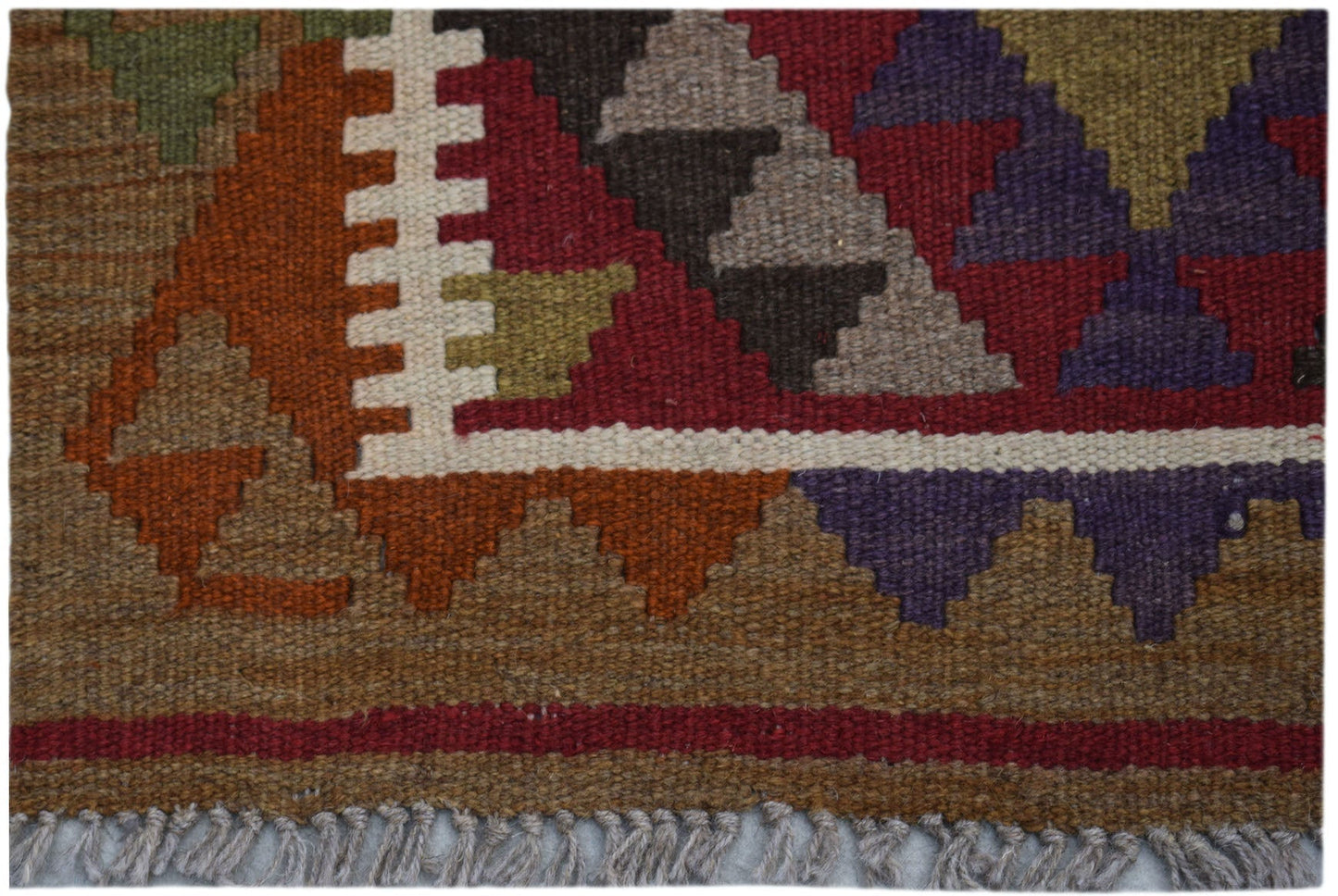 Handwoven Afghan Maimana kilim rug featuring geometric patterns in earthy tones and purple.