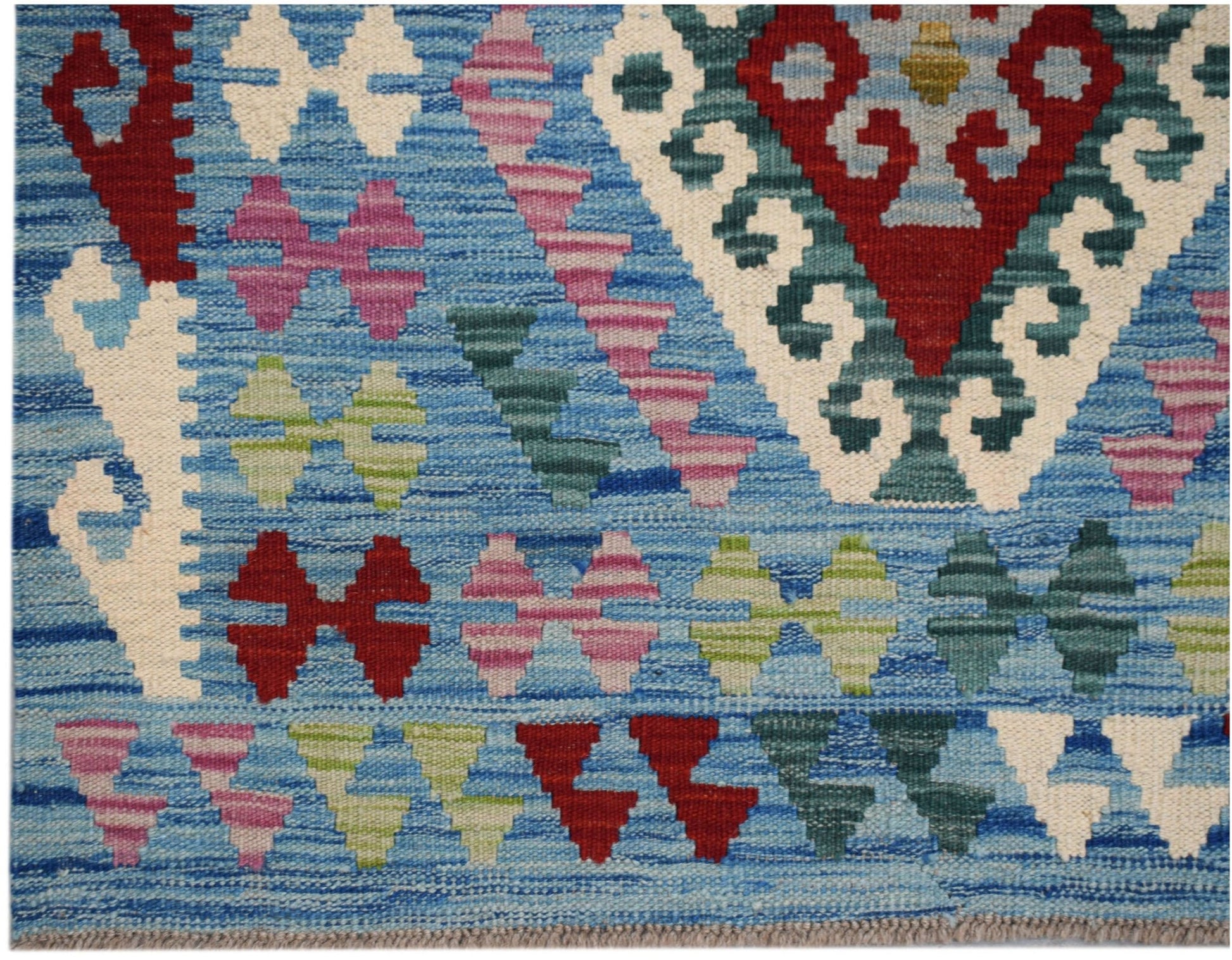 Handwoven Afghan Maimana kilim featuring a blue background with geometric patterns in wool.