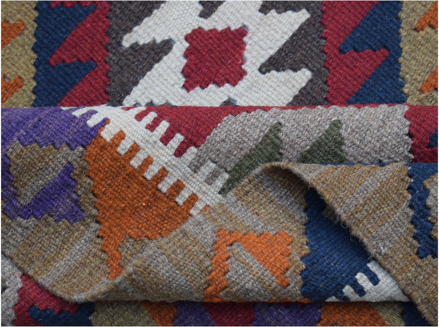 A handwoven Afghan Maimana kilim rug featuring a vibrant geometric pattern in wool.