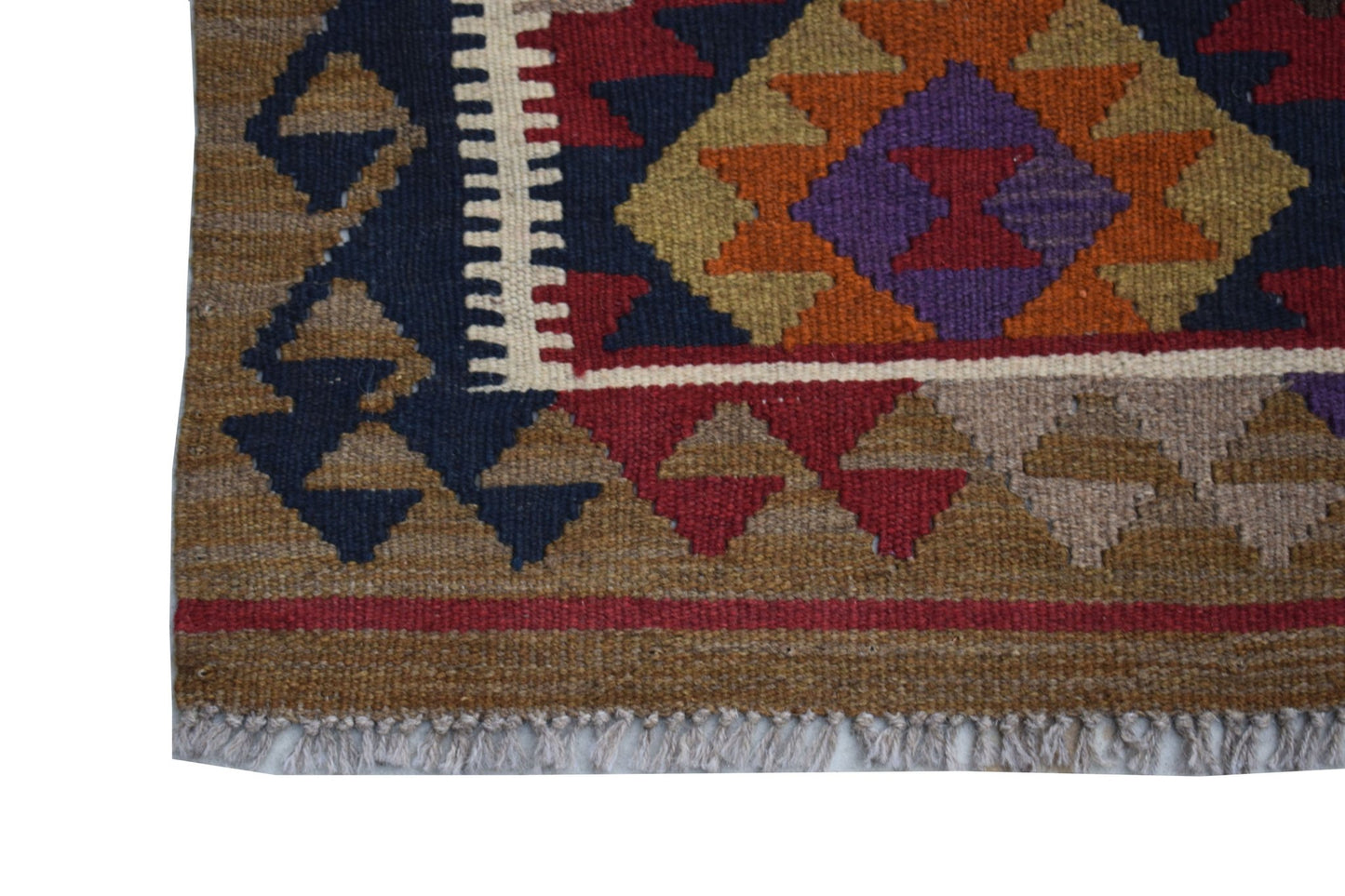 A handmade Afghan Maimana kilim featuring a geometric pattern in earthy tones and purple.