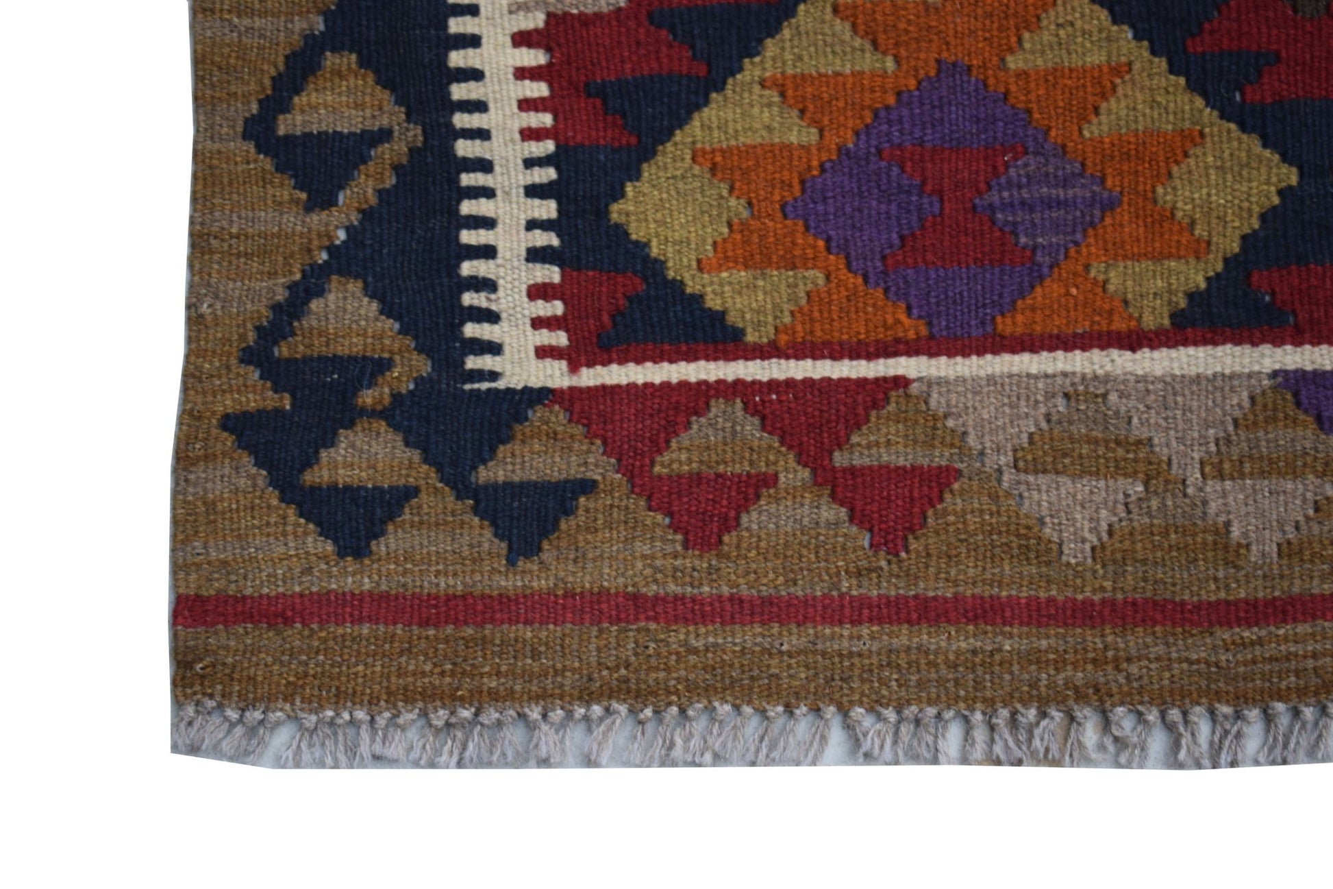 A handmade Afghan Maimana kilim featuring a geometric pattern in earthy tones and purple.