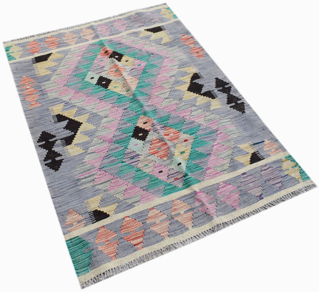 Handwoven Afghan Maimana kilim rug featuring a geometric pattern in pastel and dark tones.
