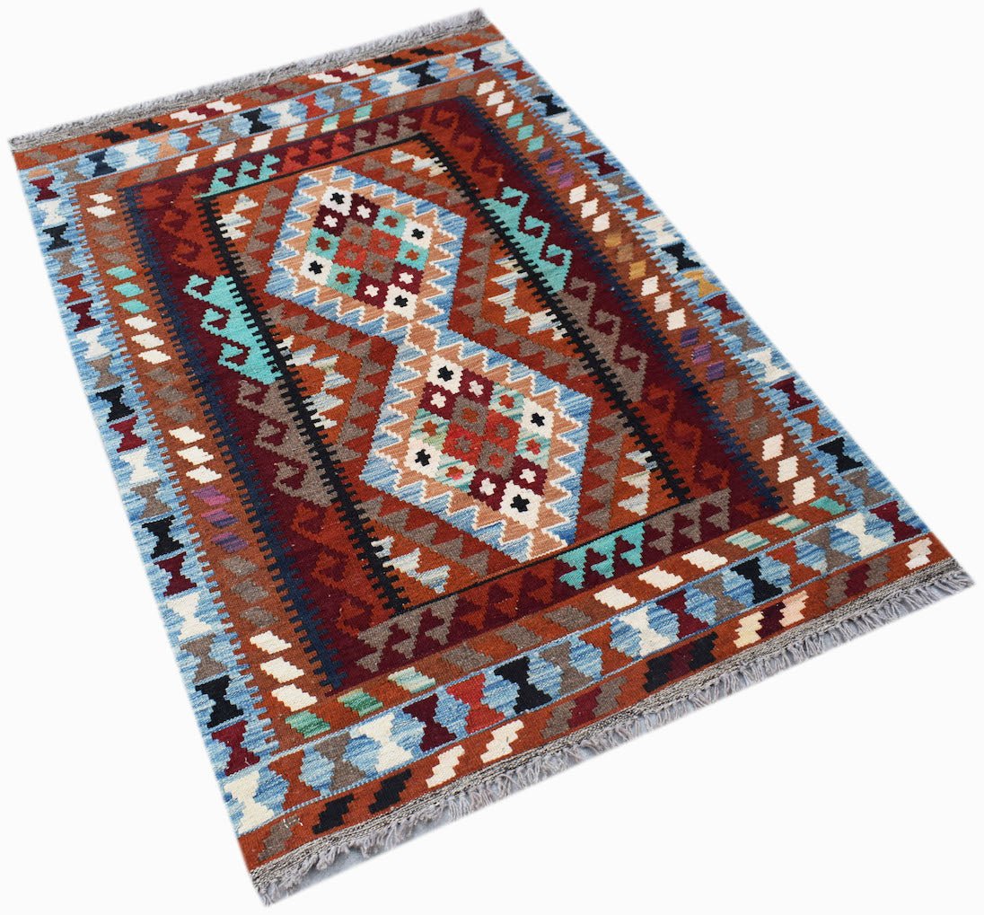 Handwoven Afghan Maimana kilim rug featuring geometric diamond patterns in red, blue, and brown.