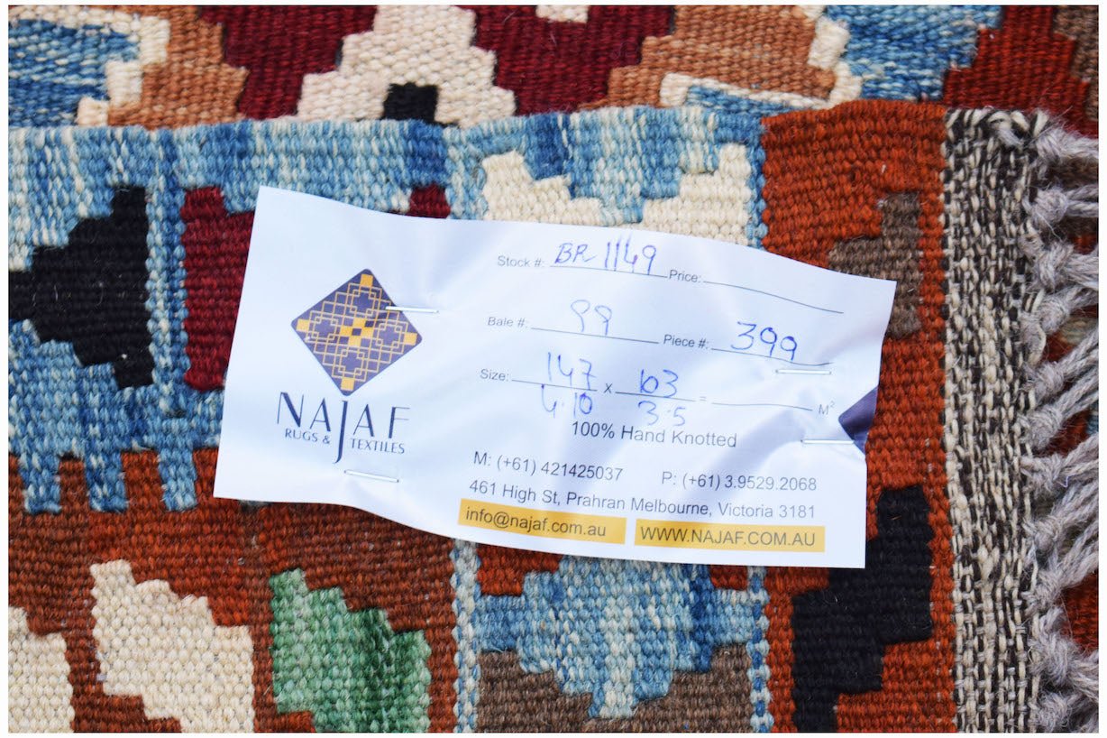 A handwoven Afghan Maimana kilim featuring a geometric pattern in blue, red, and cream wool.