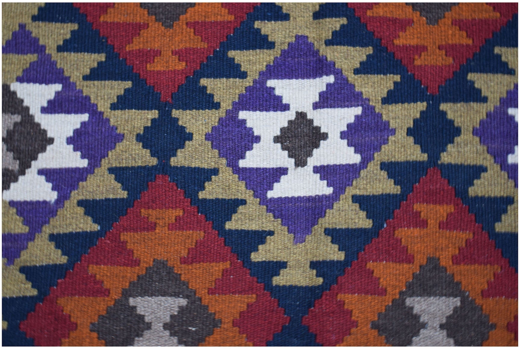 Handwoven Afghan Maimana kilim featuring a geometric diamond pattern in vibrant wool colors.
