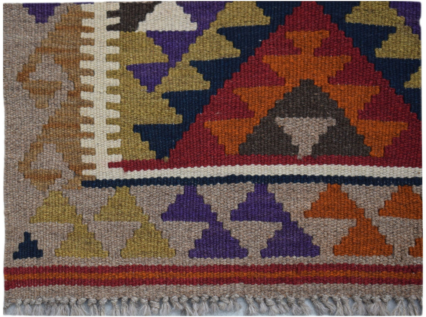 Handwoven Afghan Maimana kilim rug featuring a geometric pattern in red, blue, and earthy tones.