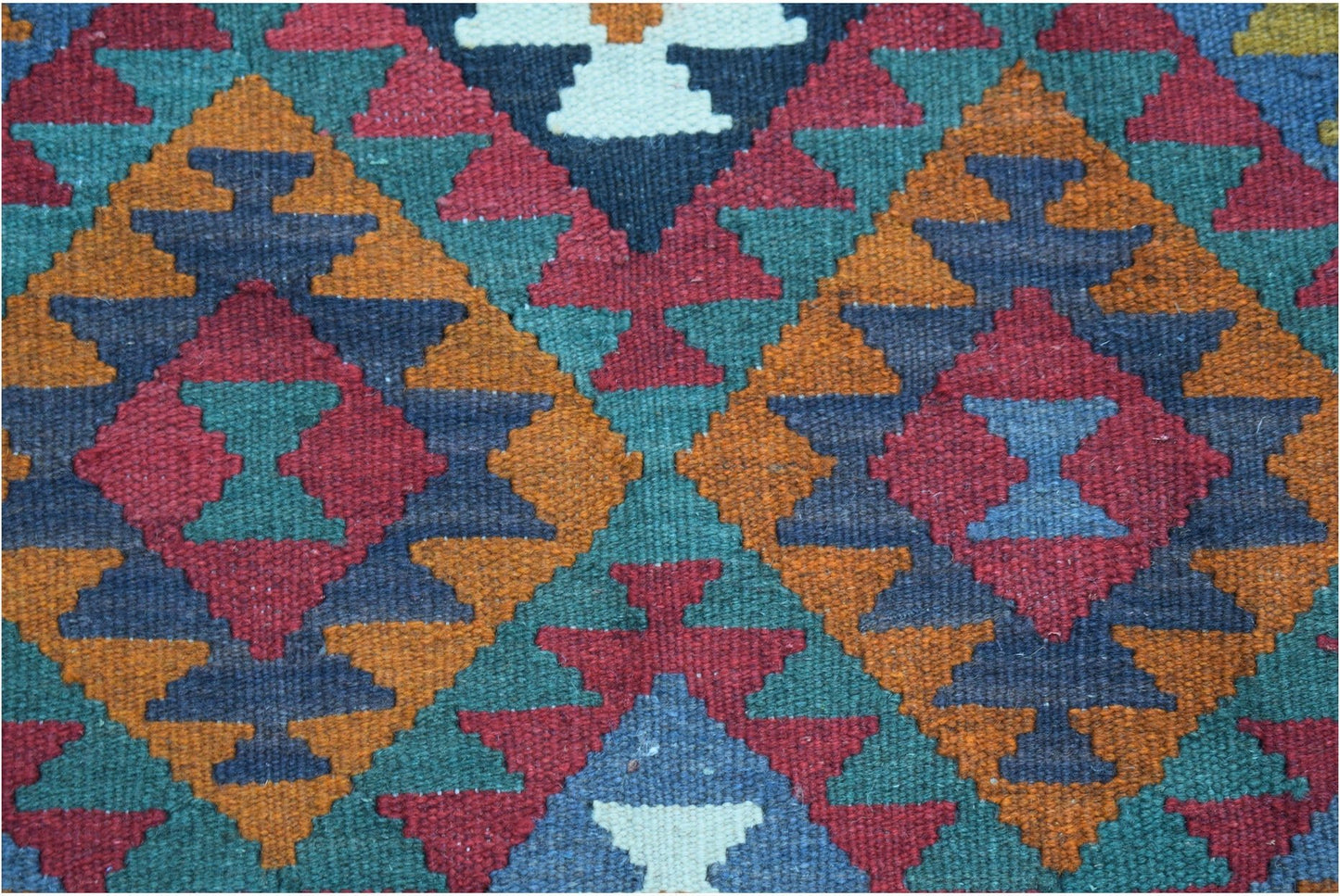 Handwoven Afghan Maimana kilim featuring a geometric pattern in red, orange, blue, and green.