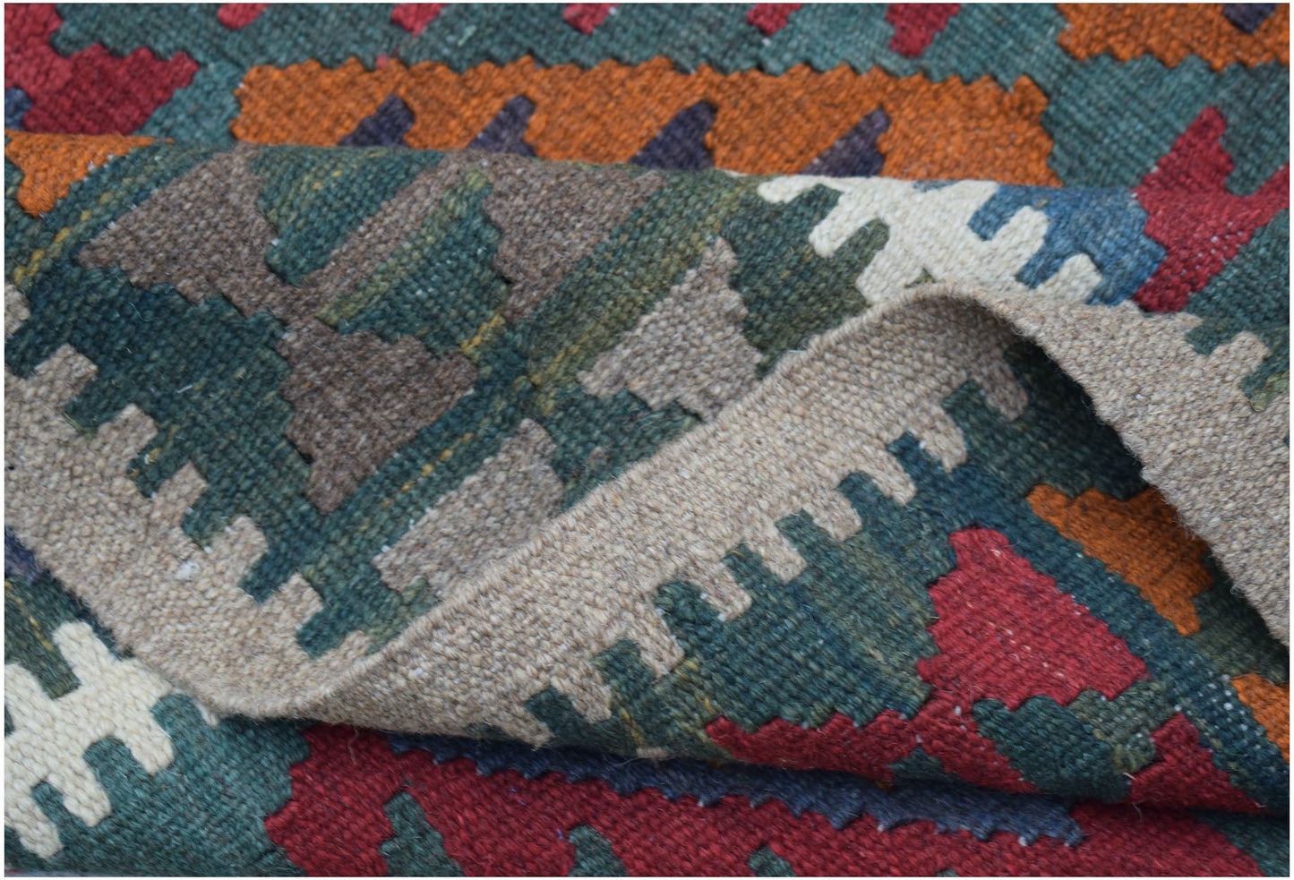 A handwoven Afghan Maimana kilim featuring a geometric pattern in red, orange, green, and beige.