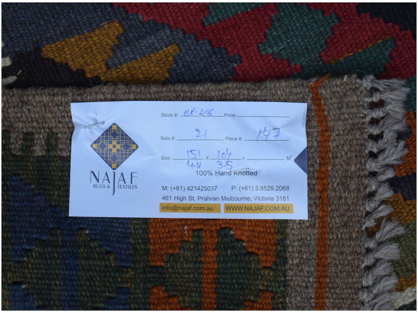 A handmade Afghan Maimana Kilim rug featuring a geometric pattern in rich, multi-colored wool.