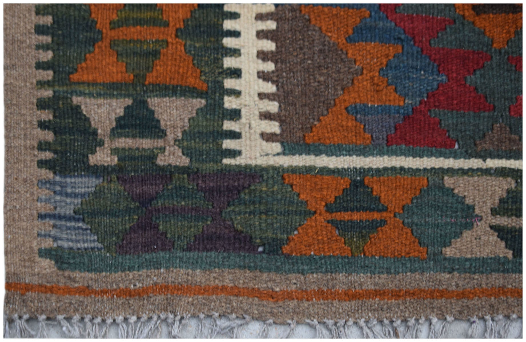 Handwoven Afghan Maimana kilim rug featuring geometric patterns in earthy tones and wool texture.