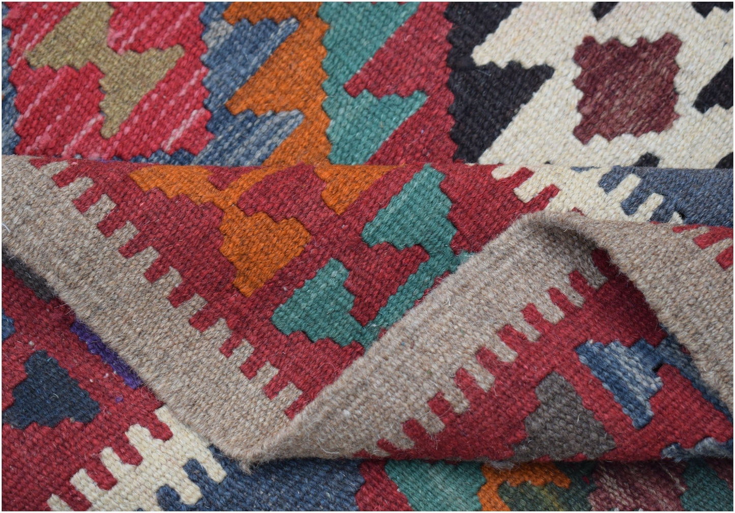 A handwoven Afghan Maimana kilim featuring a vibrant geometric pattern in wool.