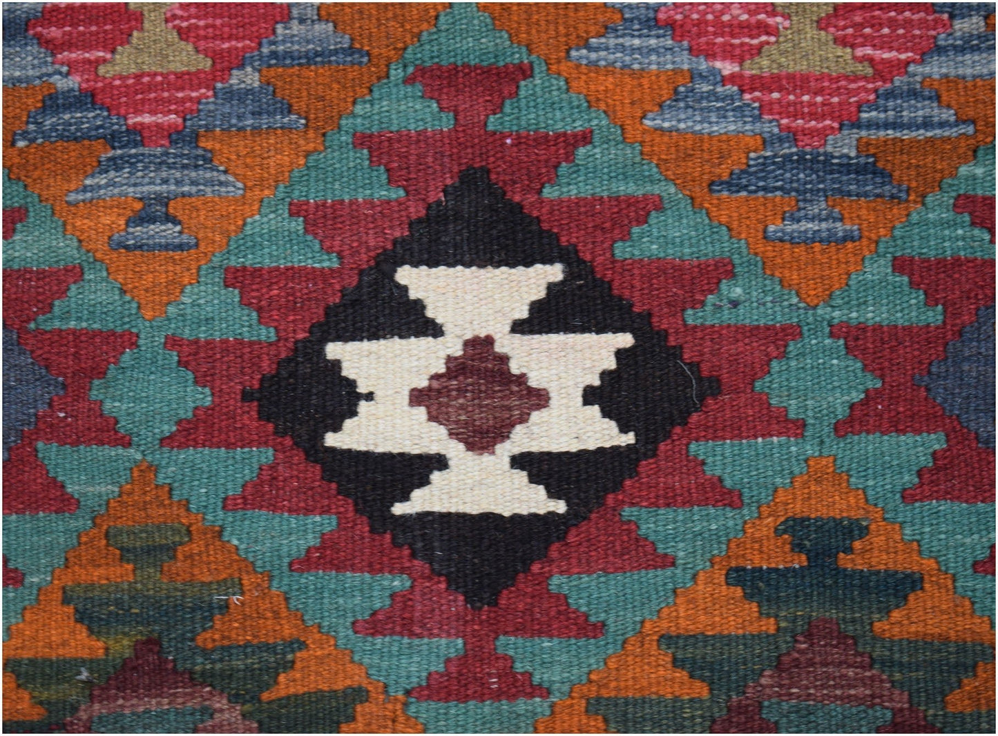 Handwoven Afghan Maimana kilim featuring a geometric pattern in red, teal, orange, and black.