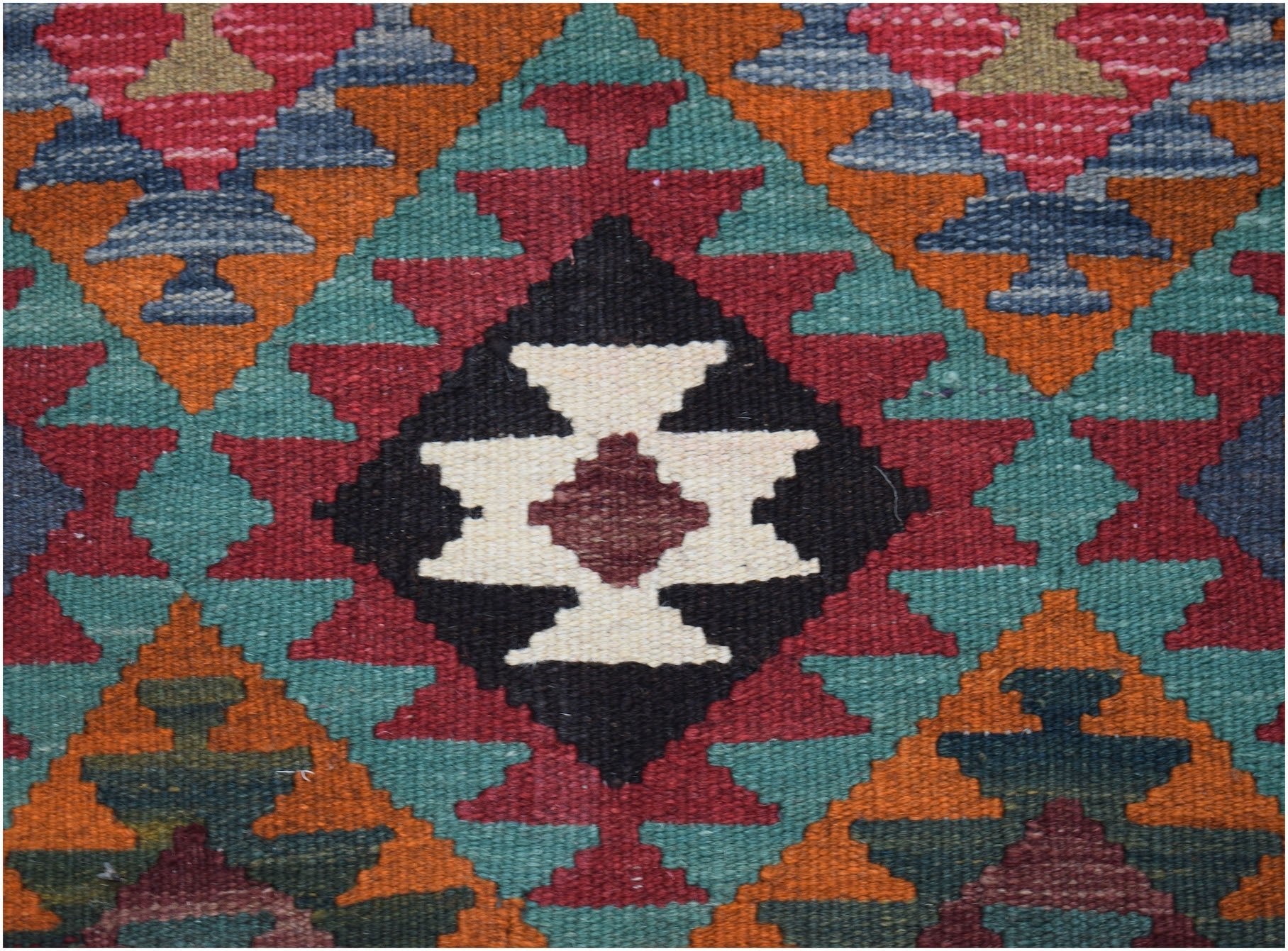 Handwoven Afghan Maimana kilim featuring a geometric pattern in red, teal, orange, and black.