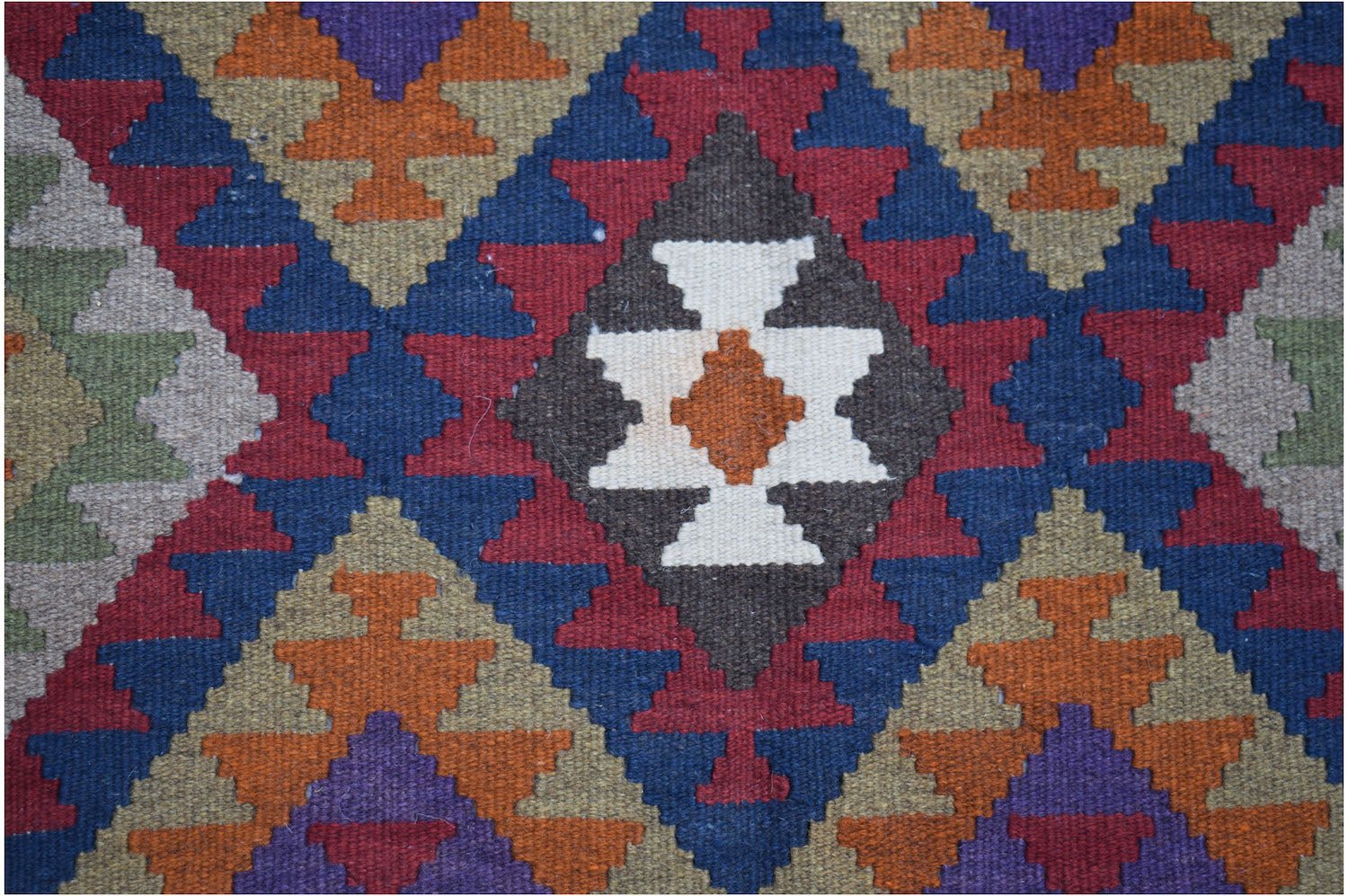 Handwoven Afghan Maimana kilim featuring a geometric diamond pattern in rich, multicolored wool.