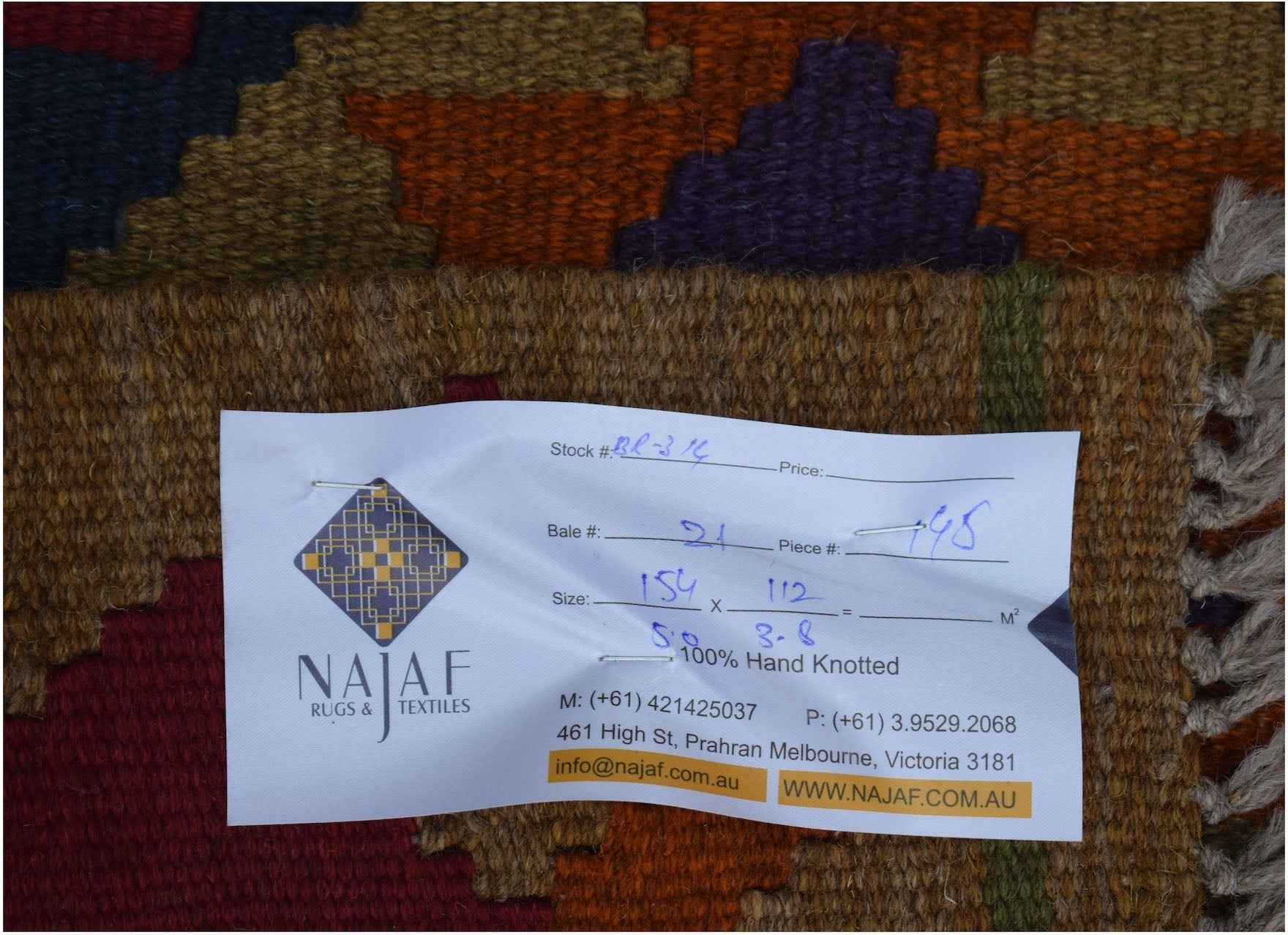 A handwoven Afghan Maimana kilim featuring a geometric pattern in rich earth tones.