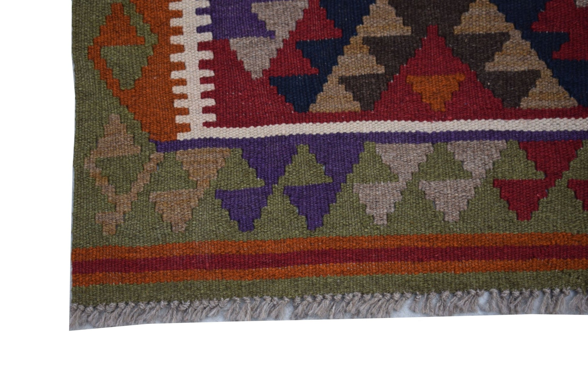 A handmade Afghan Maimana kilim featuring a geometric pattern in red, green, and purple wool.