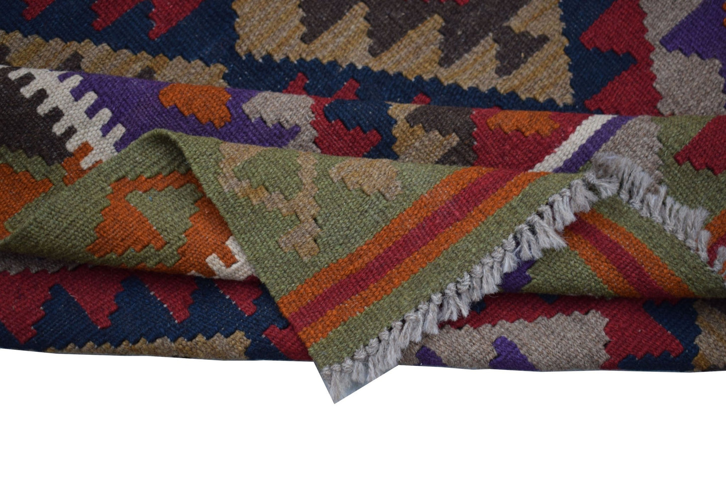 A handwoven Afghan Maimana kilim rug featuring geometric patterns in vibrant, multicolored wool.